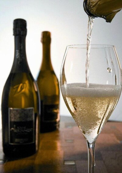 A glass of white wine being poured from a bottle. 4
