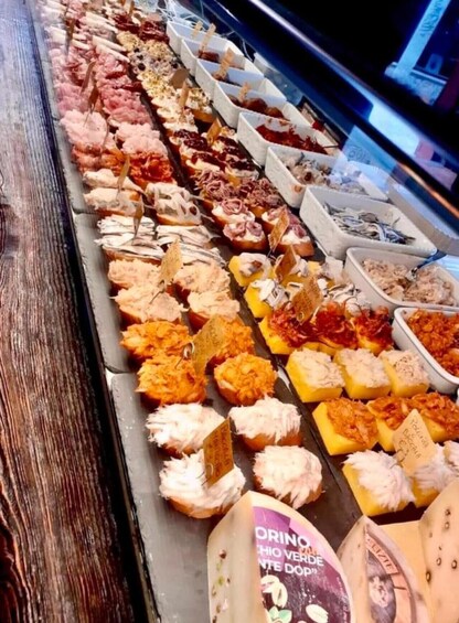 A deli display with various cheeses and cured meats. 3