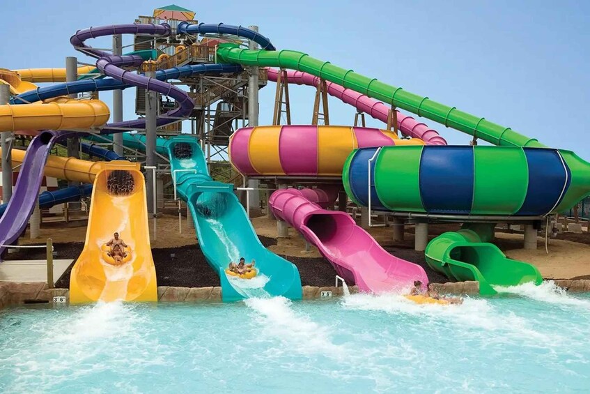A water park with multiple colorful water slides and a pool area. 1