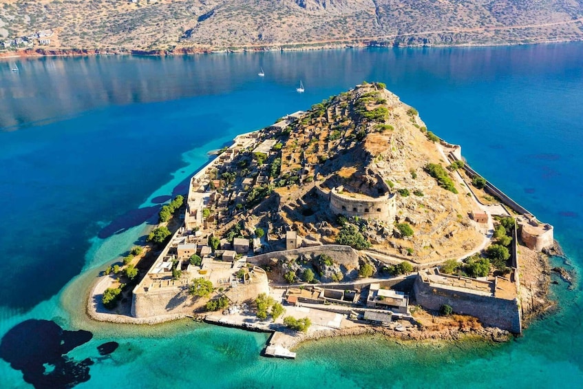 An aerial view of a fortified island with clear blue waters and a small settlement. 1