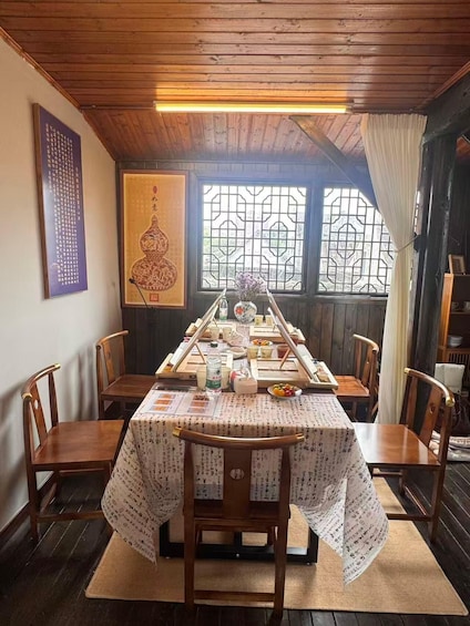 A traditional Japanese dining room with a wooden table set for a meal, surrounded by wooden chairs. 1