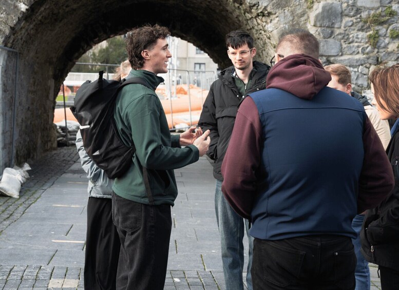 A group of people standing in a stone archway. 2