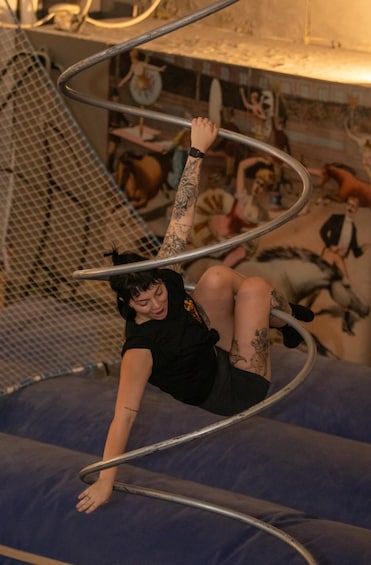 A person performing an acrobatic maneuver on a metal hoop structure. 3