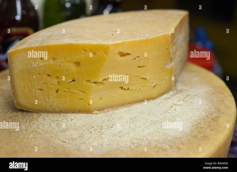 A wedge of cheese on a wooden board. 3