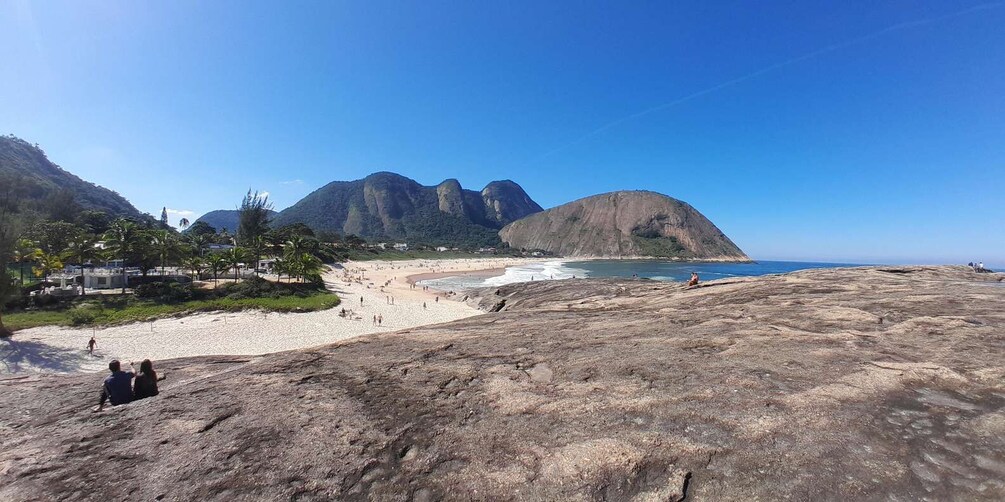 A beach with mountains in the background and a clear sky. 4