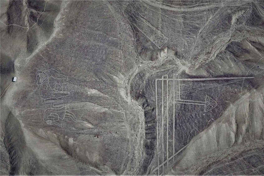 A desert landscape with ancient petroglyphs and straight lines, possibly roads or boundaries. 4
