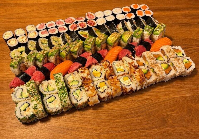 An assortment of sushi on a wooden table. 2