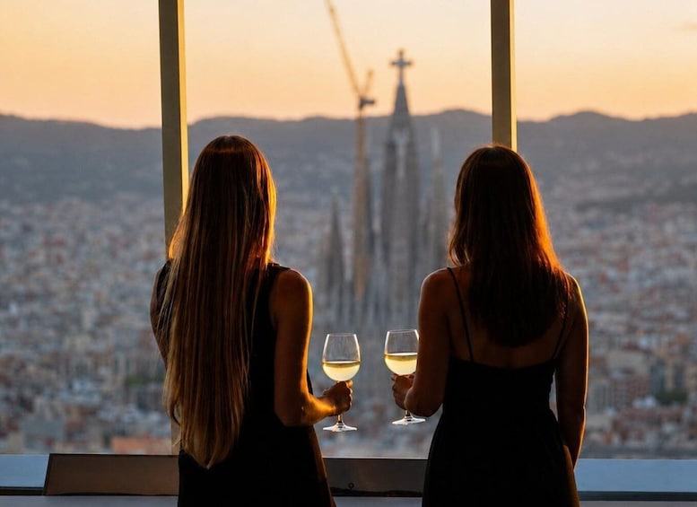 Two women sitting by a window with a cityscape and a cross in the background. 1