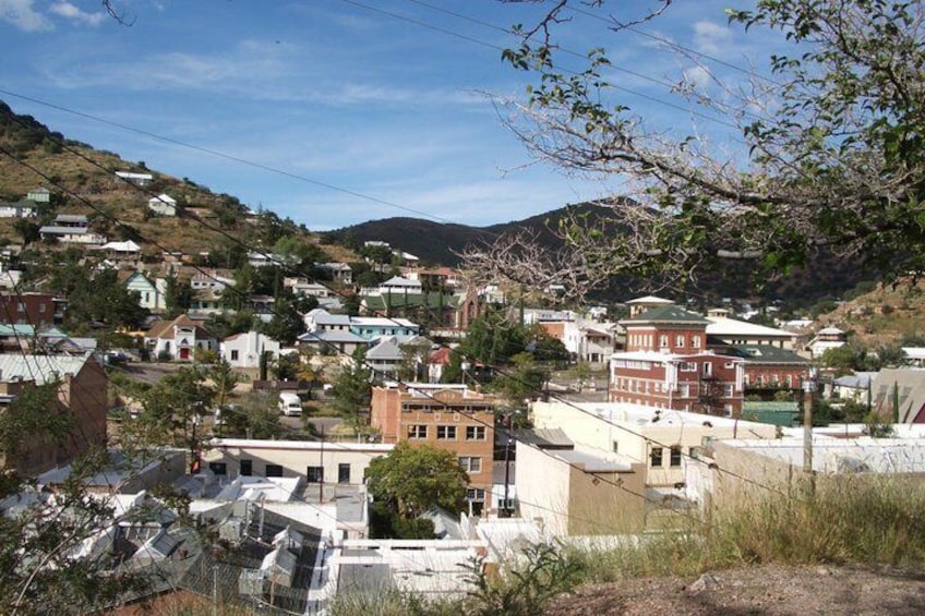 A town with buildings, a hill, and a clear sky. 3