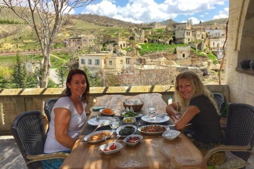 Two people dining at a table with a view of a historic village. 2