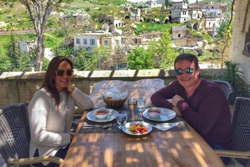 Two people dining at a table with a view of a village. 3