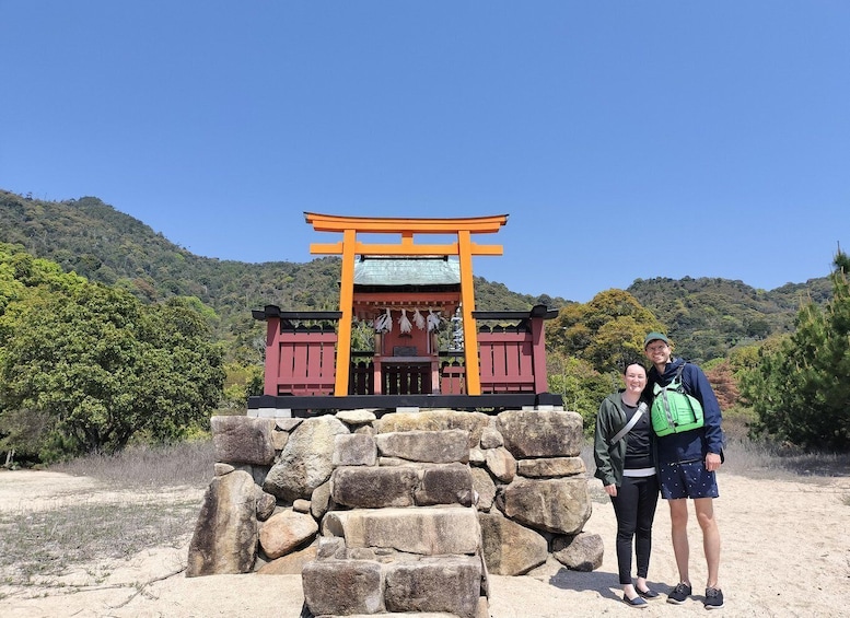 A traditional Japanese torii gate with a stone base, surrounded by a mountainous landscape. 5