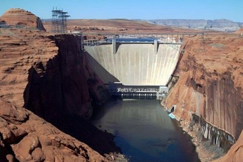 A large dam with a spillway, surrounded by red rock formations. 5