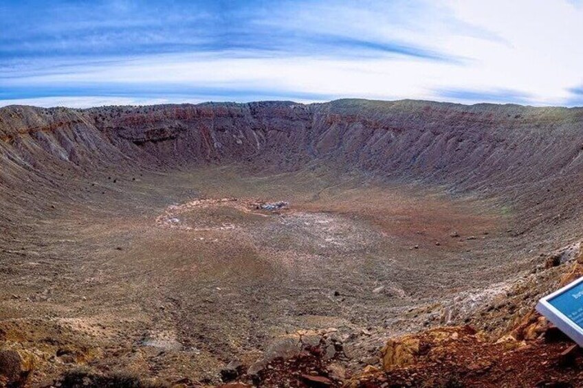 A large crater with a circular depression in the center, surrounded by a barren landscape. 4