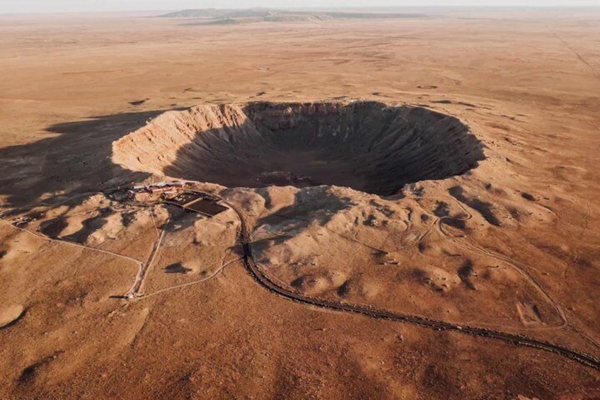 A large sinkhole with a surrounding area of dry, barren land. 1