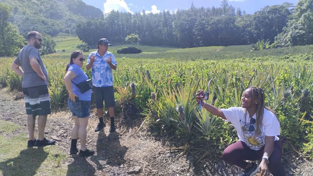 A group of people standing in a field with a woman taking a photo. 4