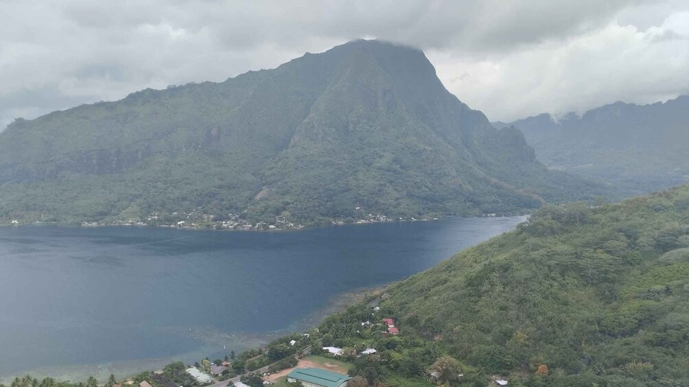 A mountainous landscape with a lake, a small settlement, and a prominent peak. 2