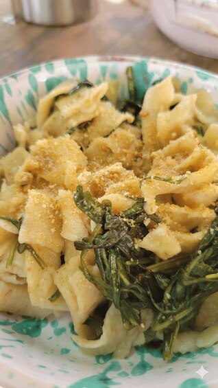 A bowl of pasta with greens and breadcrumbs. 2
