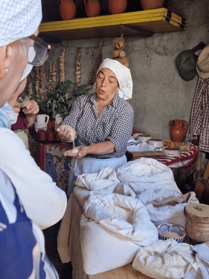 A person at a market stall with various goods and a rustic setting. 4