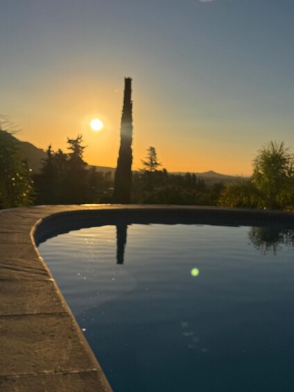 A swimming pool at sunset with a mountain in the background. 2