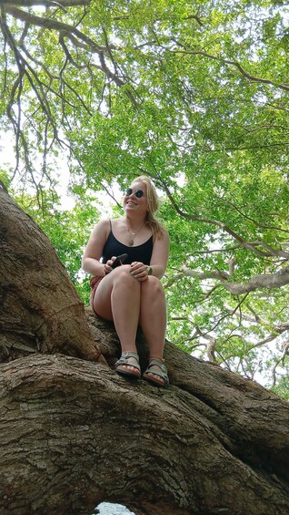 A person sitting on a tree branch. 2