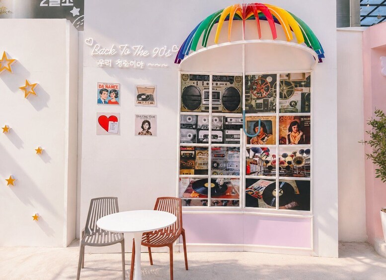 A retro-themed display with a rainbow arch, vintage posters, and a window showcasing vinyl records. 4