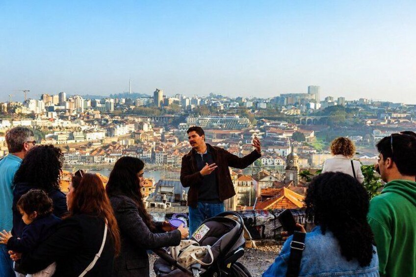 A group of people on a hill overlooking a cityscape with buildings and a river. 3