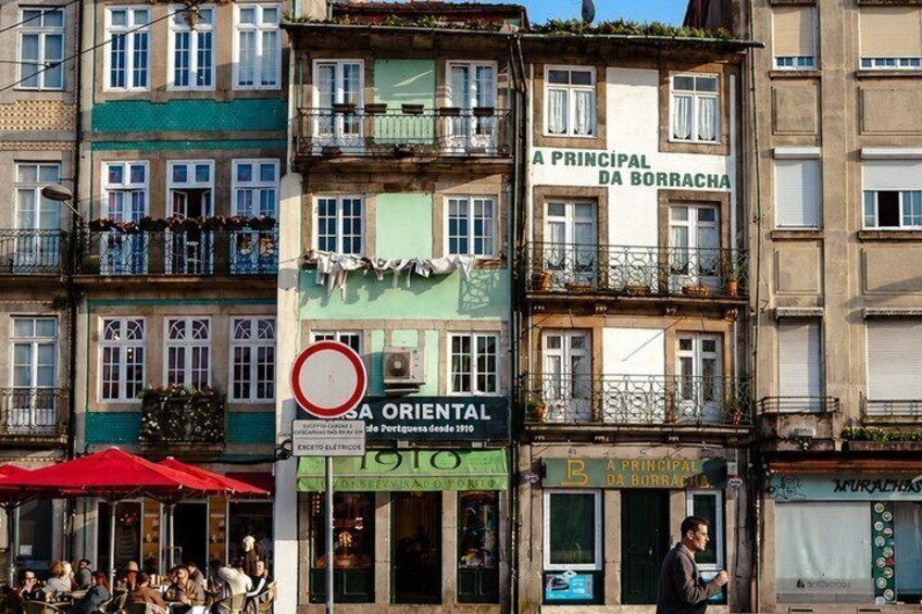 A street scene with a building labeled 'A PRINCIPAL DA BORRACHA' and a sign for 'LA ORIENTAL.' 2