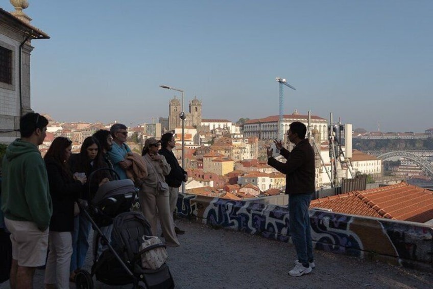 A group of people on a bridge overlooking a cityscape with historic buildings and a tower. 5