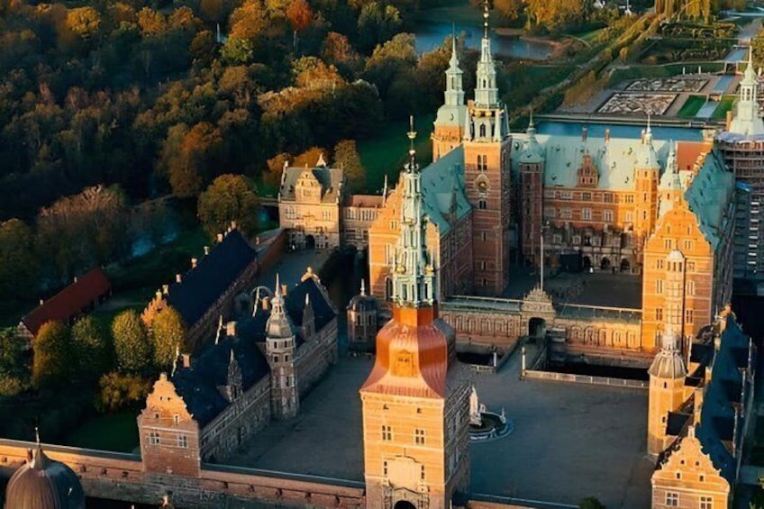 A historic castle complex with multiple towers and domes, surrounded by lush greenery. 3