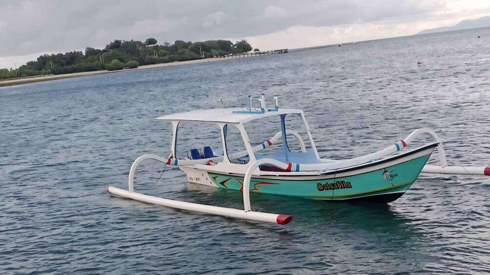 A small boat named 'Salsabila' on calm water with a distant shoreline. 5