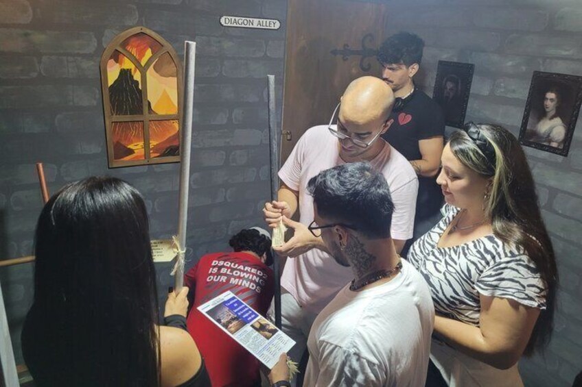 A group of people in a room with a sign reading 'DIAGON ALLEY' and a mural of a volcano. 3