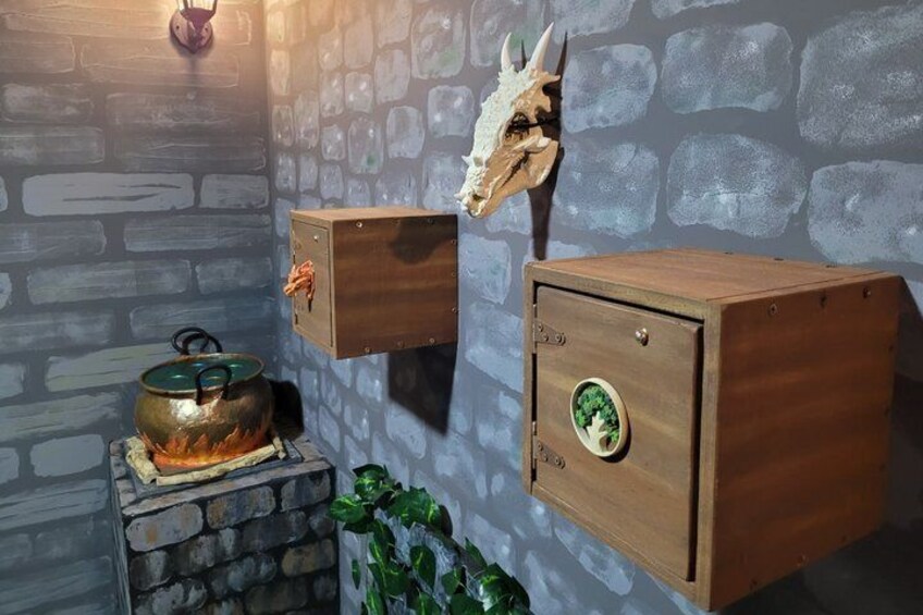 A rustic kitchen with a stone wall, a wooden chest, and a metal pot on a stove. 2