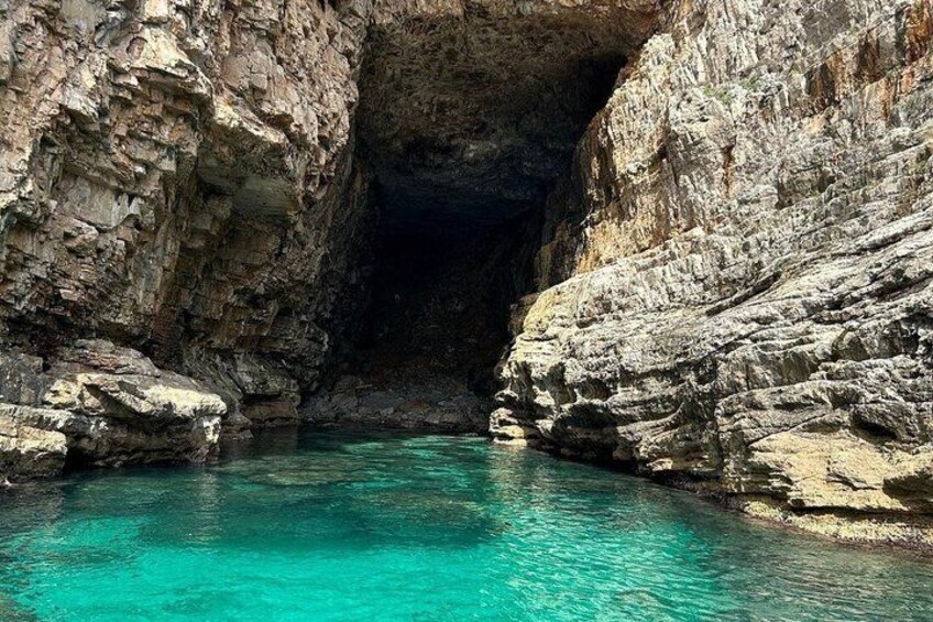 A natural rock formation with a clear turquoise pool. 4