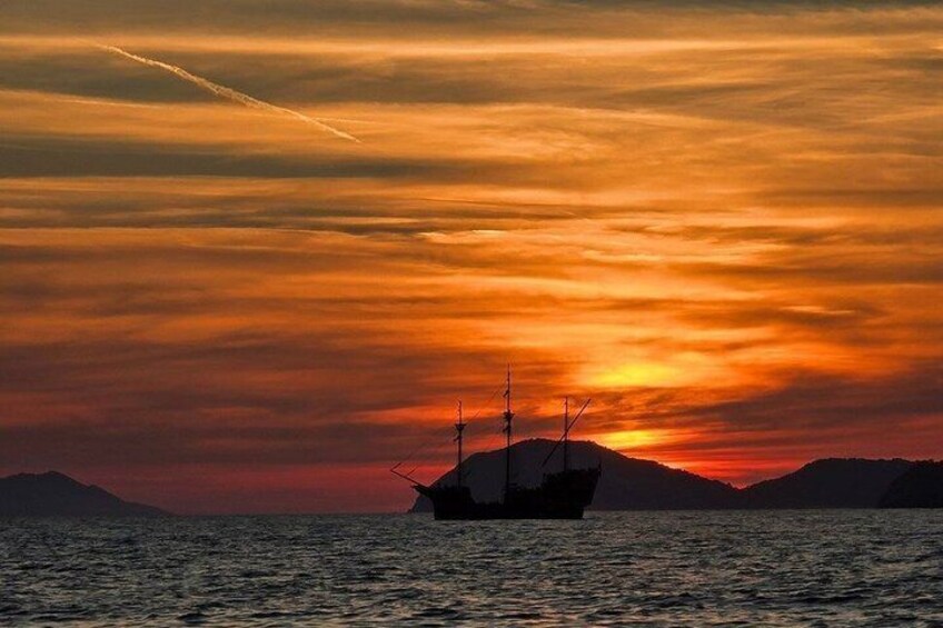 A boat on calm waters during sunset with a vibrant sky. 1