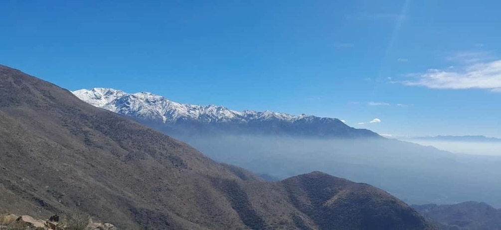 A mountain range with snow-capped peaks and a valley shrouded in mist. 4