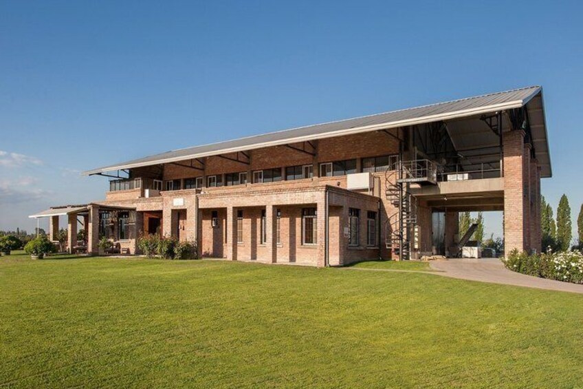 A large, modern brick building with a flat roof and a covered walkway. 3