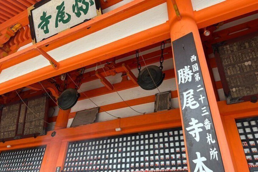 A traditional Japanese building with orange and white walls, a sign with Japanese characters, and a lattice window. 5