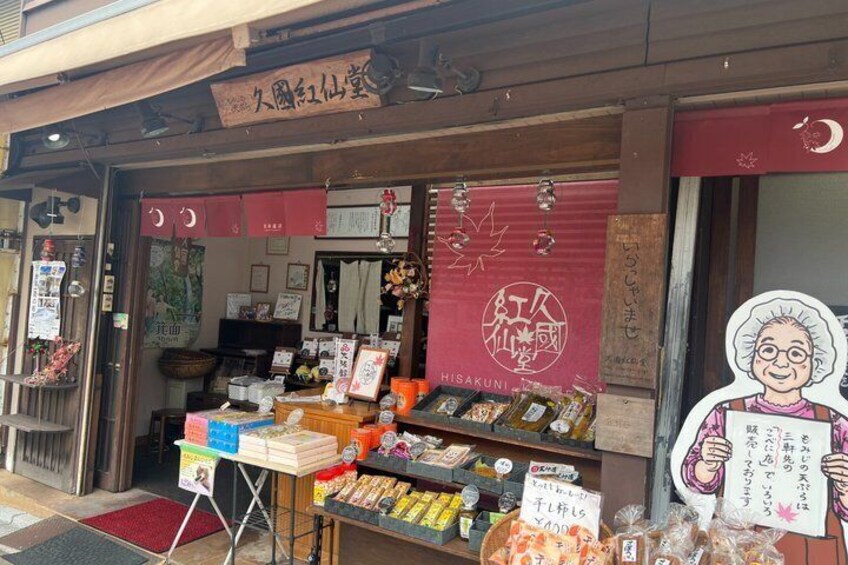 A Japanese shop with a red awning and a signboard. 3