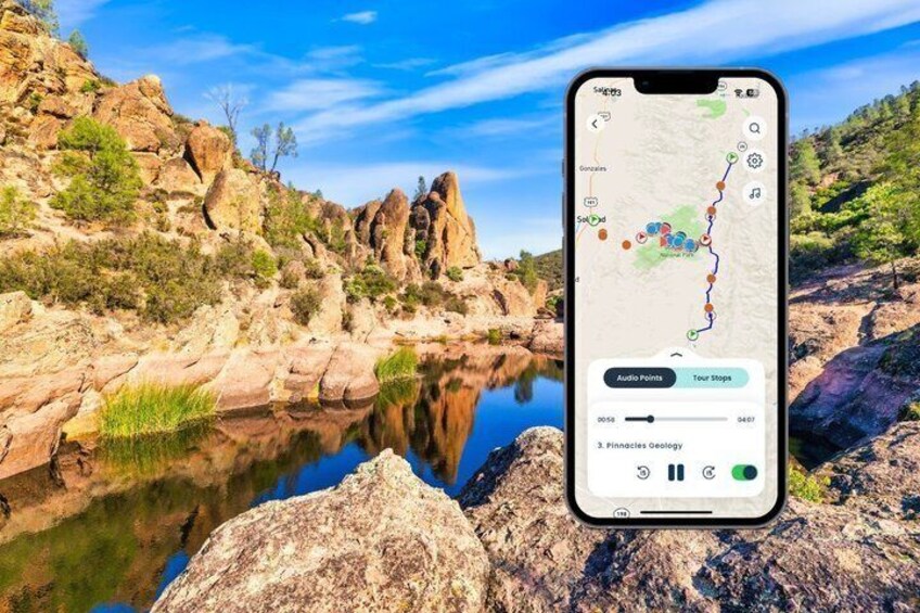 A smartphone displaying a map with audio points and tour stops over a rocky landscape with a reflective water body. 1