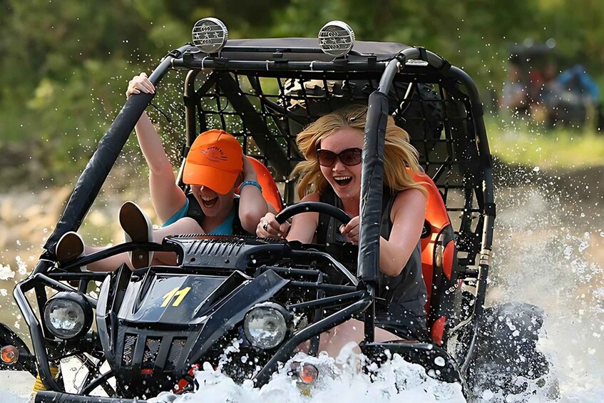 A person driving a vehicle through water, splashing around. 4