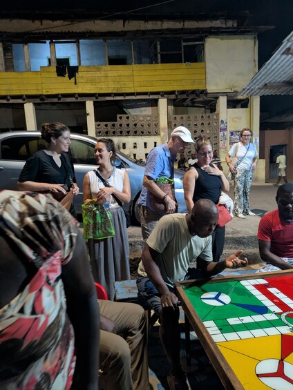 A group of people playing a board game outdoors. 3