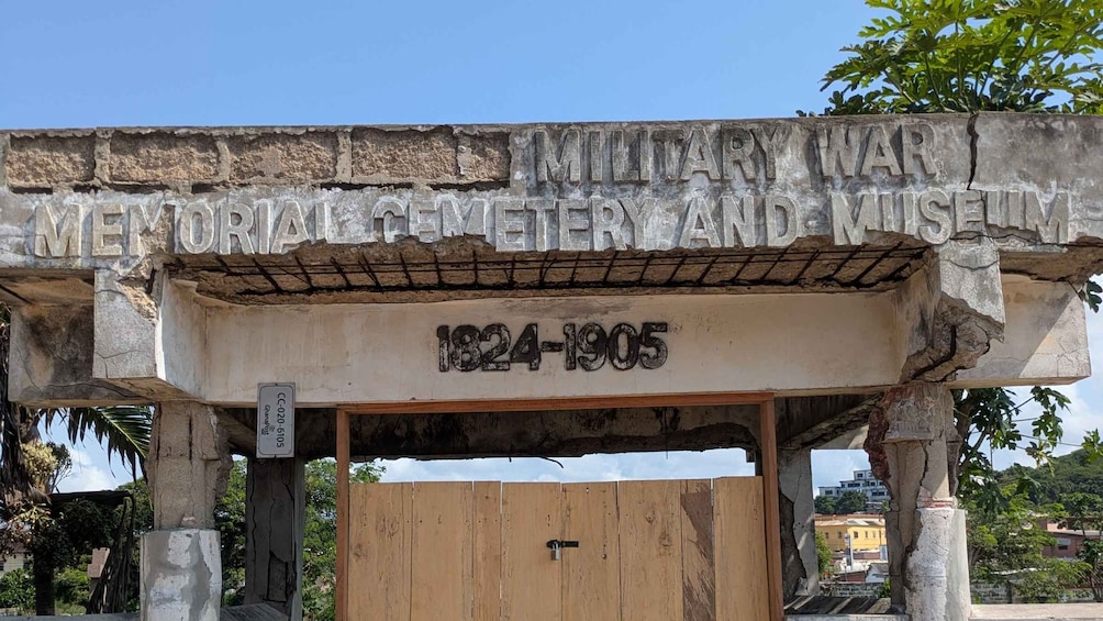 A weathered stone monument with inscriptions marking the Military Cemetery and War Museum, dating from 1824 to 1905. 2