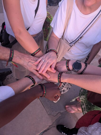 A group of people placing their hands together in a circle. 4
