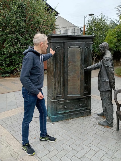 A person interacting with a statue of a man. 4