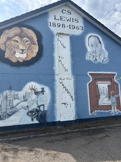 A mural on a building with a lion, a man, and a girl. 1