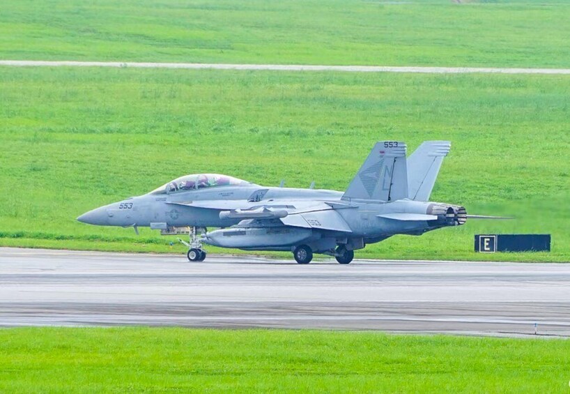A military aircraft with the number 553 on a runway. 5