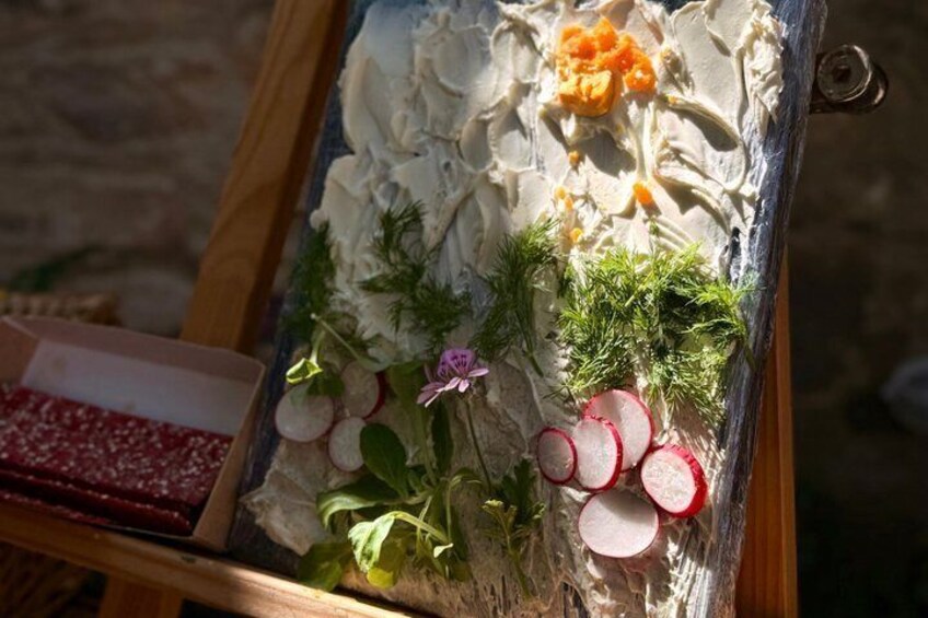 A food display with cream cheese, radishes, dill, and a small flower. 3