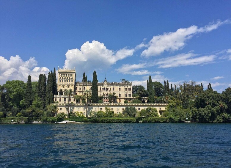 A historic building with a tower, surrounded by trees and water. 2