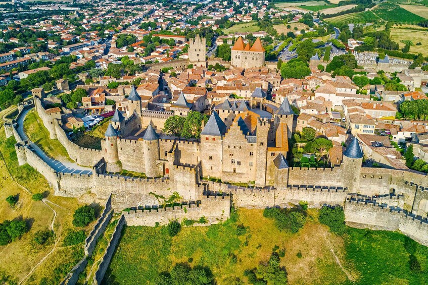 A medieval castle surrounded by a walled town with red-roofed buildings and a river. 2